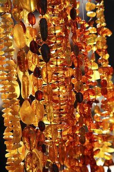 some very pretty orange beads hanging from a rack with other things on it's sides