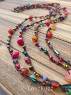 multicolored beaded necklace sitting on top of a wooden table