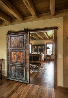 an open wooden door in the middle of a room with zebra rugs on the floor