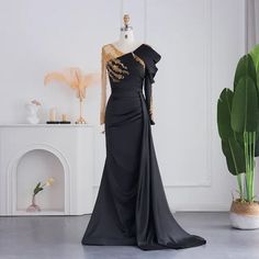 Luxury Black Satin Design: The dress features a luxurious black satin material, exuding elegance and sophistication, making it an ideal choice for upscale events and special occasions, particularly for weddings. Mermaid Silhouette: The mermaid silhouette elegantly accentuates your figure, creating a striking and alluring look that ensures you stand out and feel radiant at any event. Beaded Overskirt Detail: The addition of a beaded overskirt adds an element of drama and elegance, creating a stun Arabic Evening Dress, Arabic Fashion, Satin Design, Party Gown, Mermaid Silhouette, Satin Material, Formal Party, Party Gowns, Black Satin