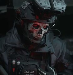 a man wearing a helmet with skulls on it's face and holding a cell phone