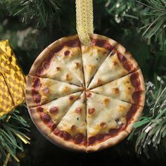 a homemade pizza ornament hanging from a christmas tree with pine cones on it