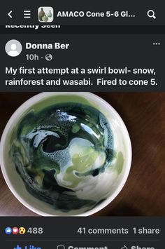 a bowl filled with green liquid sitting on top of a wooden table