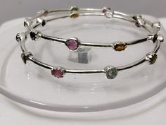 Beautiful Silver bangles exquisitely crafted by hand and designed with love. Genuine Handmade Tourmaline Bangle 925 Sterling Silver Flower Bangle-Multi Tourmaline Flower Bangles-Gemstone Bangle-multi Tourmaline Bangle > sold By 2 Piece PRODUCT DETAILS :- > Material - 925 Sterling Silver > Gemstone - Pink Tourmaline (100 %real ) > Gemstone shape - Oval > Gemstone Weight - 6.30 Ct > Gemstone Size- 4.6 mm > Setting - Pave setting > Gross Weight- 10.60 Grams Production Time: Each of our pieces are m Round Stackable Tourmaline Jewelry, Stackable Round Tourmaline Jewelry, Silver Tourmaline Adjustable Jewelry, Adjustable Silver Tourmaline Jewelry, Multicolor Gemstone Bangle, Sterling Silver Bangle With Natural Stones, Tourmaline Birthstone Jewelry, Silver Bangles Design For Women, Silver Bangles Design For Women Indian