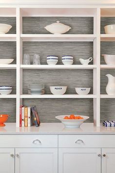 a white shelf with bowls and plates on it