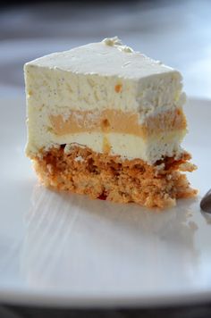 a piece of cake sitting on top of a white plate next to a silver spoon