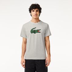 A T-shirt designed for intense exercise by Lacoste, sporting experts since 1933. Made from technical jersey, with cotton for comfort and Ultra Dry technology to wick away moisture. Plus an iconic, XL crocodile print for Lacoste signature style. Sporty Logo T-shirt For Sports, Functional Athletic Heather Crew Neck Top, Crew Neck T-shirt For Light Sports, Gray Crew Neck T-shirt For Light Sports, Athletic Heather T-shirt With Logo For Sports Season, Sporty Athletic Heather T-shirt With Moisture-wicking, Technical Gray Crew Neck Top, Short Sleeve Logo T-shirt In Athleisure Style, Athletic Heather Crew Neck Top For Light Sports