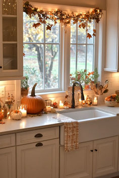 a kitchen filled with lots of candles next to a sink and window covered in fall decorations