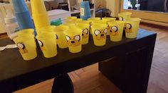 yellow cups with faces painted on them sitting on a table