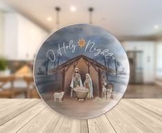 a glass plate with a nativity scene on it sitting on top of a wooden table