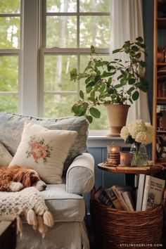 a living room with a couch, chair and bookshelf in front of a window