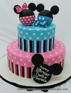 a three tiered cake decorated with mickey and minnie mouse ears