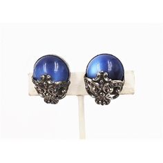 This is part of Chairish’s Costume Jewelry assortment.  1950s Baroque style silvertone blue moonglow clip back earrings. Marked "Napier." Condition: Very good; a normal amount of tarnish for their age. Measure:  1 3/16 inches long by 7/8 inches wide. Identical earrings are shown on pg. 279 of Melinda L. Lewis & Henry Swen's book "The Napier Co.: Defining 20th Century American Costume Jewelry."  Please reference the measurements noted in the description above for the best approximate dimensions. American Costume, Book Pieces, Baroque Style, Moon Glow, Baroque Fashion, Accessories Jewelry Earrings, Clip Earrings, Vintage 1950s, Costume Jewelry