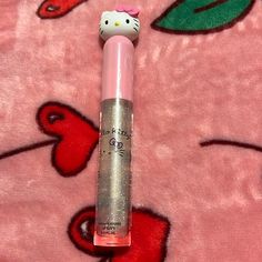 a hello kitty lip balm sitting on top of a pink blanket