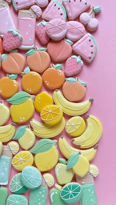 a pile of decorated cookies sitting on top of a pink table