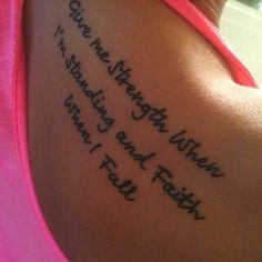 the back of a woman's shoulder with tattoos on it and words written in cursive writing