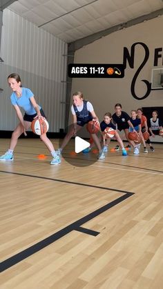 a group of people on a court with basketballs in hand and one person holding a ball