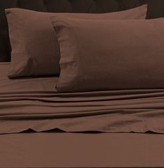 a bed with brown sheets and pillows on it