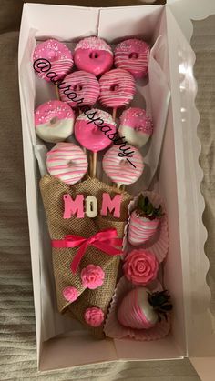 pink and white decorated cookies in a box