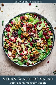 a salad with apples, cranberries and walnuts in a bowl on a table