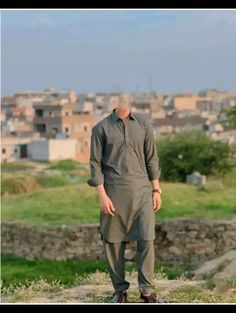 an old man standing in the middle of a field with his hands on his hips