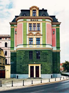 an old building painted green and pink on the corner