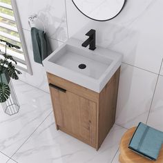 a white sink sitting on top of a wooden cabinet next to a mirror and potted plant