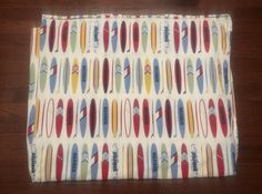 a close up of a cloth on a wooden floor with surfboards all over it