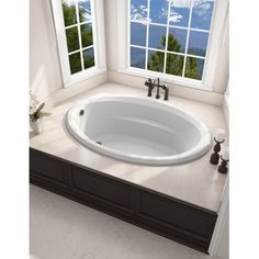 a white bath tub sitting next to two windows