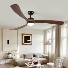 a living room with a ceiling fan in the middle of it's centerpiece