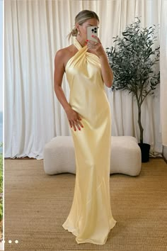 a woman in a yellow dress taking a selfie