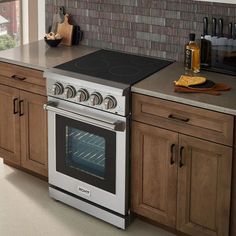 a stove top oven sitting inside of a kitchen next to wooden cabinets and counter tops