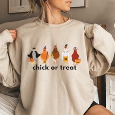 The comfortable fit and cool design of this chick or treat sweatshirt means that it feels just as good to wear as it is to look at. If you've been looking for a spooky chicken sweatshirt for yourself, or your favorite chicken loving friend, you should get this sweatshirt today. Ideal for any situation, a unisex heavy blend crewneck sweatshirt is pure comfort. These garments are made from polyester and cotton. This combination helps designs come out looking fresh and beautiful. The collar is ribb Funny Print Sweatshirt For Fall, Cute Fall Sweatshirt With Funny Print, Fall Sweatshirt With Funny Print And Relaxed Fit, Novelty Cotton Tops For Fall, Chickens Shirts, Chicken Sweatshirt, Halloween Chicken, Chicken Clothes, Chicken Sweater