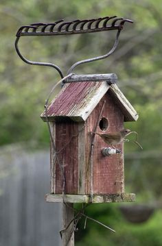 a wooden birdhouse hanging from the side of a pole with a wire attached to it