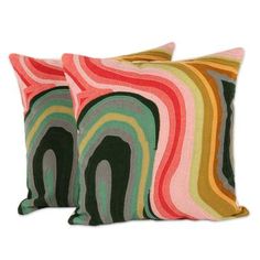 two colorful pillows sitting next to each other