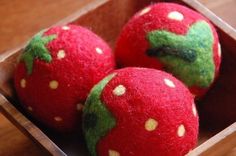 three red apples with green leaves in a wooden box on a table, ready to be eaten