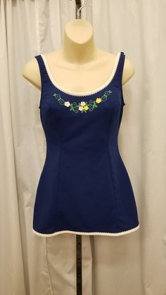 Vintage Catalina 60's Playsuit Swimsuit One Piece Navy Blue w White Trim & Embroidered Flowers Bathing Suit Beachwear Romper Poolside Swimwear Made in USA.  Swimwear is in excellent condition - (see pics).  Fabric does stretch!  The shoulder straps are adjustable. Skirt covers the bottom swimsuit area.  Inside bra has built in support. Measurements: waist 28, bust 34, front length from top of shoulder strap to crotch 29, length shoulder strap to bottom of skirt 25 1/2, shoulder to shoulder 13 1/ 80s Swimwear, 1960s Swimwear, 50s Bathing Suit, 80s Swimsuit, Adjustable Skirt, Vintage Playsuit, Modest Bathing Suit, Feminine Wardrobe, Vintage Bathing Suits