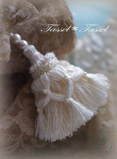 two white tassels are sitting on a lace doily with the words trust and trust