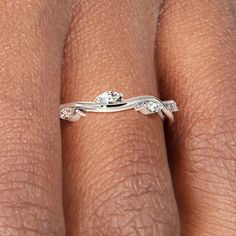 a woman's hand with a diamond ring on her left hand and the other hand holding an engagement ring