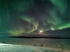 the aurora bore is shining brightly in the night sky over an icy lake and snow covered ground