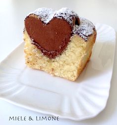 a piece of cake on a white plate with a heart shaped frosting in the middle