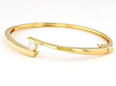 Pre-Owned Moissanite Fire® .60ct diamond equivalent weight round, 14k yellow gold over sterling silver bangle bracelet. Measures  approximately 7 & 1/4" L x 7/16" W. and has a  box clasp. Actual moissanite weight is .54ct. .  This product may be a customer return, vendor sample, or on-air display and is not in its originally manufactured condition.  It may not be new.  In some instances, these items are repackaged by JTV. Formal Diamond Bangle With Single Diamond, Formal Bangle With Single Diamond, Formal Fine Jewelry Bangle With Single Diamond, Modern Round Diamond Bracelet With Single Diamond, Formal Oval Bangle With Diamond Accents, Formal Gold Bracelet With Single Diamond, Formal Fine Jewelry Gold Bracelet With Single Diamond, Modern Bangle With Single Diamond, Modern Gold Bracelet With Diamond