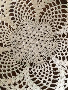 crocheted doily on the ground with white yarn