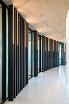 an empty room with black and white striped wall covering the entire length of the room