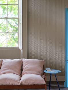 a couch and table in a room with a window on the far wall, next to a blue cabinet