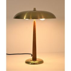 a table lamp with a wooden base and a light bulb on the top is turned on