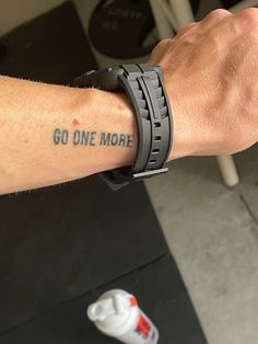 a man's arm with a wristband that says go one more on it