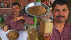 two men sitting at a table with some food in front of them and one holding a spoon