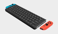 an orange and blue controller next to a black keyboard on a gray background with the same color