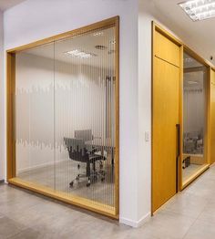 an office with glass walls and wooden doors